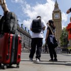 Una persona carga una maleta con la Torre Isabelina, comúnmente conocida como Big Ben, al fondo, en Parliament Square, Londres, Reino Unido, 12 de mayo de 2025.