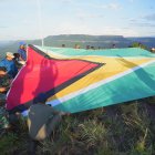 hombres desplegando una bandera de Guyana en la montaña Pakrampa, en la aldea de Arau, región Esequibo (Guyana).