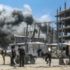 Palestinos intentan refugiarse mientras se eleva el humo tras un ataque aéreo israelí al oeste de la ciudad de Gaza, en la Franja de Gaza, el 23 de mayo de 2025.