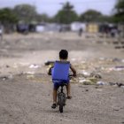 Un niño migrante venezolano monta su bicicleta en el campamento de migrantes La Pista en Maicao, departamento de La Guajira, Colombia, el 22 de abril de 2025.