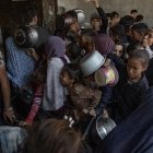 Cientos de palestinos se amontonan frente al Comedor Social Sokar en la Ciudad de Gaza para conseguir raciones de comida.