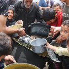 Palestinos buscan conseguir un poco de comida para calmar el hambre.
