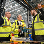 El primer ministro británico, Keir Starmer (centro), y el secretario de Defensa británico, John Healey (izq.), conversan con un miembro del personal durante una visita a las instalaciones de Govan de BAE Systems en Glasgow, el 2 de junio de 2025.
