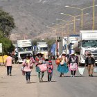 Personas caminan por una carretera tras un bloqueo realizado por seguidores del exmandatario Evo Morales este lunes, en Sipe Sipe en la región de Cochabamba (Bolivia).