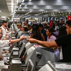 Los viajeros entregan documentos al personal de la aerolínea en el Aeropuerto Internacional de Miami durante el 24 de mayo de 2025 en Miami, Florida.