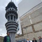 El artista de Bradford Saad Qureshi junto a la "Torre del Ahora", una obra que busca reunir en una sola figura las distintas culturas que habitan en la Ciudad de la Cultura del Reino Unido 2025.