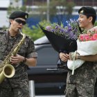 RM toca el saxofón junto a su compañero de banda V, mientras sus fans disfrutan de su salida, luego de completar 18 meses de servicio militar obligatorio.