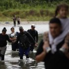 Migrantes que cruzan el río Tuquesa luego de atravesar la selva del Darién en el Darien (Panamá).