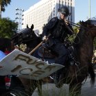 Agentes del Departamento de Policía de Los Ángeles se enfrentan a los manifestantes.
