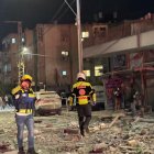 Integrantes de equipos de emergencia, bomberos y policía, trabajan en el área donde un proyectil iraní impactó provocando el derrumbe de un edificio en la madrugada de este domingo.