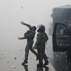 Un integrante de la Unidad de Control de Multitudes (UCM) lanza una granada de gas lacrimógeno durante una manifestación este sábado