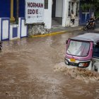 Conductor de moto taxi que circula por una calle inundada, tras el paso del huracán "Erick", enOaxaca (México).