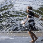 Una niña se refresca en una fuente de agua en Georgetown Waterfront Park en Washington (Estados Unidos).