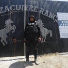 Integrante de la fiscalía estatal resguardando la entrada al Rancho Izaguirre en el municipio de Teuchitlán, Jalisco (México).