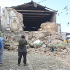 Personas observan este miércoles una edificación destruida por los temblores ocurridos el martes, en Santa María de Jesús (Guatemala).