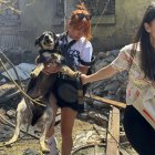Unas chicas locales llevan un perro en el lugar de un ataque con drones en Odesa, Ucrania, el 11 de julio de 2025.