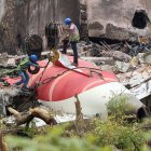 Fotografía del 14 de junio de 2025 que muestra a trabajadores indios que retiran los restos del avión de Air India con una grúa del lugar del accidente, cerca del aeropuerto de Ahmedabad.