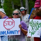 Personas sostienen carteles durante una manifestación este sábado 12 de julio, frente el centro de detención de migrantes "Alligator Alcatraz" en Ochopee, Estados Unidos.