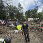 Personas recogen escombros en las zonas afectadas por las recientes inundaciones, en Kerrville (EE.UU.).
