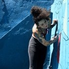 La artista Karina "Kau" Taveras pinta un mural este miércoles, en la Perla en San Juan (Puerto Rico).