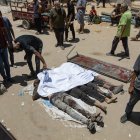 Palestinos lloran sobre los cuerpos de los acribillados.