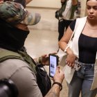 Un agente federal usa información en su teléfono mientras detiene a una mujer fuera de las audiencias del tribunal de inmigración Nueva York, Nueva York, EE. UU..