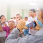 Adultos mayores aprenden a usar la tecnología que tiene un celular.