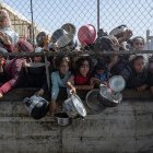 Palestinos desplazados se agolpan para recibir alimentos en Jan Yunis, en el sur de la Franja de Gaza.