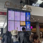 Viajeros observan los itinerarios de sus vuelos en el Aeropuerto El Dorado en Bogotá (Colombia), en una fotografía de archivo.