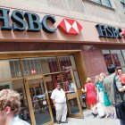 La gente camina por delante de una de las sucursales del Banco HSBC.