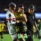 Un jugador de Sao Paulo lleva en sus brazos a Joao Rojas, tras su lesión en el partido ante Barcelona en Copa Libertadores.