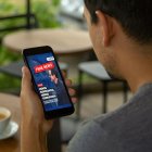 Una persona revisa en su celular una imagen que imita el diseño de Diario EXPRESO, parte de una campaña digital que busca posicionar mensajes políticos mediante montajes con apariencia de medios reales.