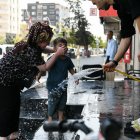 Calor. Las personas pausan su paso para refrescarse con agua en la calle.