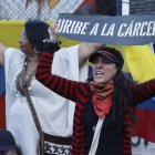 Una detractora del expresidente de Colombia, Álvaro Uribe, sostiene un cartel frente al Complejo Judicial de Paloquemao este lunes, en Bogotá (Colombia). El "juicio del siglo" en Colombia partió en dos la historia judicial del país al imponer en primera instancia una condena a 12 años de prisión y otras sanciones al expresidente Álvaro Uribe (2002-2010), quien consideró "sesgado" el proceso y la sentencia de la jueza Sandra Heredia. EFE/ Mauricio Dueñas Castañeda