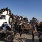 Palestinos desplazados internos suben a camiones de ayuda para conseguir comida en el sur de la Franja de Gaza, el 4 de agosto de 2025.