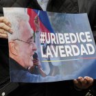 Una persona que sostiene un cartel en apoyo al expresidente colombiano Álvaro Uribe, condenado a doce años de cárcel.