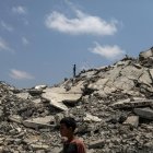 Un niño palestino (atrás) se encuentra sobre los escombros de un edificio destruido en la parte norte de la Franja de Gaza, el 8 de agosto de 2025.