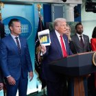 El presidente de Estados Unidos, Donald Trump, sostiene un documento junto al secretario de Defensa, Pete Hegseth (2-i), mientras se dirige a los medios de comunicación en Washington.