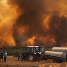 Varios vecinos observan el incendio forestal en Alvite, Moimenta da Beira, Viseu, Portugal.
