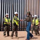 Secretaria de Seguridad Nacional de Estados Unidos, Kristi Noem saludando a un funcionario en frente del muro fronterizo entre Estados Unidos y México.