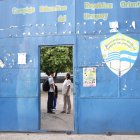 Una educadora del Complejo Educativo República Oriental del Uruguay, revisa el corte de cabello a un estudiante este miércoles, en San Salvador (El Salvador).