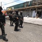 Integrantes de los Grupos Operativos Especiales de Seguridad (GOES) custodian locales comerciales afectados por la explosión, este viernes en Cali (Colombia).