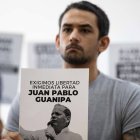 Ramón Guanipa sostiene un cartel de su padre detenido, Pedro Guanipa, en una imagen reciente.