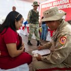 Un funcionario de la Milicia Bolivariana de Venezuela registra a una mujer durante una jornada de alistamiento este sábado, en Caracas (Venezuela).