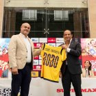 Pie de foto: El presidente de la FEF, Francisco Egas, (d) entrega una camiseta conmemorativa al vicepresidente de mercadeo y gestión de clientes de Corporación Favorita, Jesús Azofeifa, como parte de la alianza entre ambas instituciones.