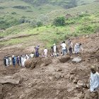 Personas caminando junto a un deslizamiento de tierra que sucedió este domingo, en Tarsin (Sudán).
