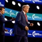 Donald Trump sube al escenario tras ser presentado por Charlie Kirk (izq.) en la conferencia Turning Point Action, el 15 de julio de 2023 en West Palm Beach, Florida.