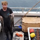 El pescador Chris Kelly, de 32 años, que utiliza redes para sus capturas, posa con un pulpo capturado a bordo de su barco "Shadow", en el suroeste de Inglaterra.