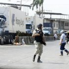 Guardias de seguridad de las terminales de la isla Trinitaria custodian las cargas que llegan.