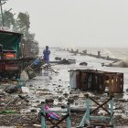 Un hombre se encuentra cerca de escombros en una carretera costera en medio de fuertes lluvias debido a los patrones climáticos del súper tifón Ragasa en la ciudad de Aparri, Filipinas.